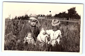 Mädchen mit Puppen Gras Landschaft Lattenzaun Echt Foto Postkarte RPPC C206 - Bild 1 von 2