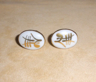 Gemelos ovalados blancos de los años 50 con símbolo asiático metálico dorado de Victoria Flemming Foto 1 de 4