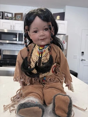 Muñeca de porcelana coleccionable con un nativo americano con traje tradicional de piel de ciervo Foto 1 de 4