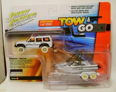 JEEP CHEROKEE XJ V/A W/ BOAT AND TRAILER CHASE TOW & GO JOHNNY LIGHTNING 2023 - Image 1 of 3