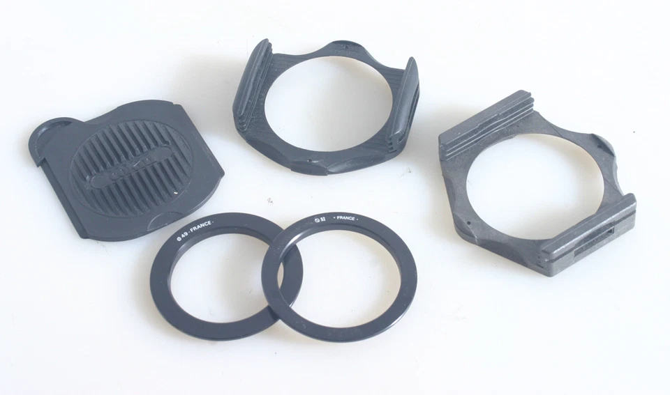2 COKIN ADAPTER RING HOLDERS WITH 49MM AND 52MM ADAPTER RINGS AND COVER 5 PIECES - Image 1 of 1
