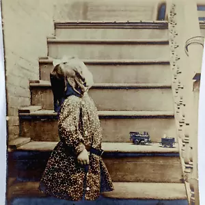 Antica foto ragazza che guarda lontano dalla scala della macchina fotografica con locomotiva giocattolo - Foto 1 di 3