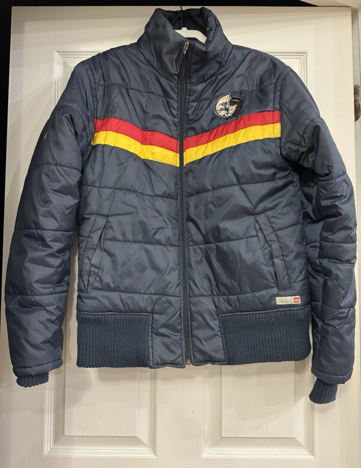 Chaqueta acolchada retro Quicksilver azul marino con rayas rojas y amarillas y logotipo M Foto 1 de 4