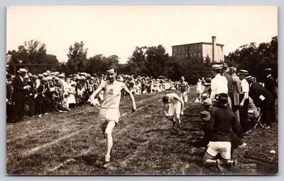 Runner Breaking Tape at Finish Line of an Outdoor Track & Field Competition RPPC - Image 1 of 2