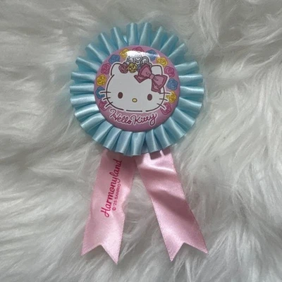 Hello Kitty Rosettenabzeichen rosa & blaues Band Sammlerstück Harmonie Land gebraucht - Bild 1 von 2