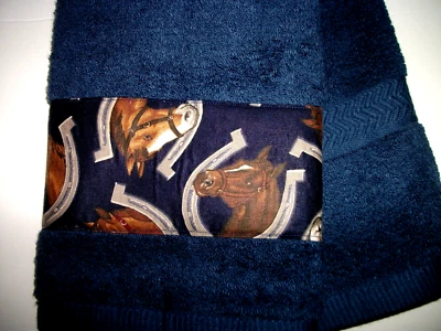 MATERIAL DISEÑADO CABALLO Y HERRADURAS, COSIDO EN UNA TOALLA AZUL MARINO Foto 1 de 3