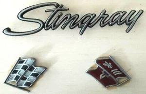 VINTAGE 1969 CHEVROLET CORVETTE FLAGS AND 'STINGRAY' SCRIPT ORIGINAL METAL TRIM - Foto 1 di 4