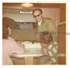 FOUND COLOR PHOTO R_1349 MAN BY PEOPLE SITTING AT TABLE