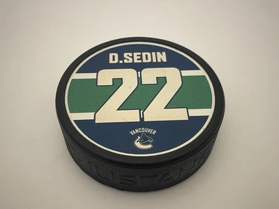 Disco de hockey oficial Vancouver Canucks Daniel Sedin #22 Foto 1 de 4