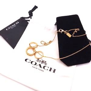 Hermoso collar colgante Coach tono dorado con dije y anillos firma precio de venta sugerido por el fabricante 125 USD - Imagen 1 de 5