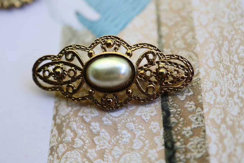 Broche prendedor de colección con perla sintética y con diseños desplazados en tono dorado ~ seminuevo Foto 1 de 1