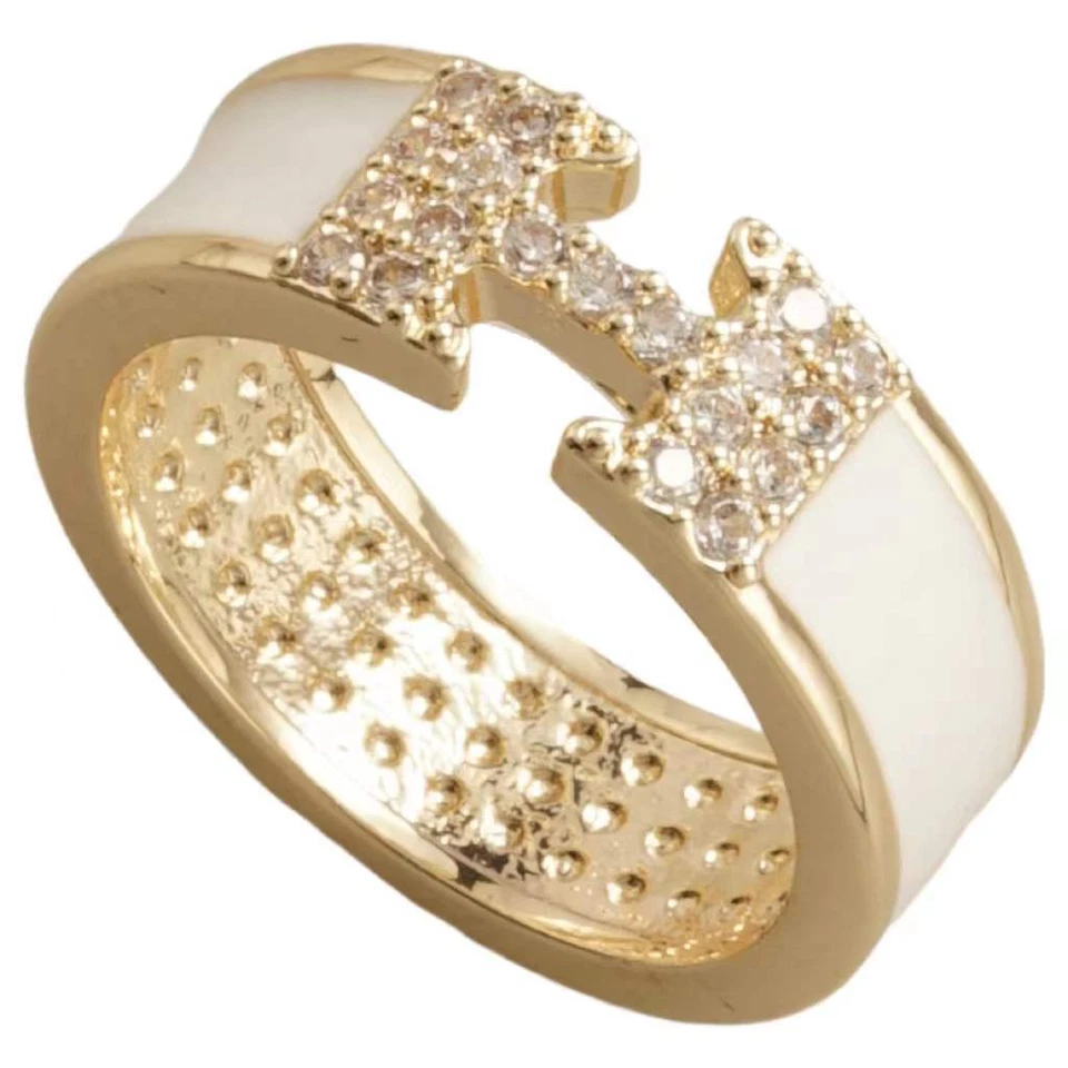 ANILLO INSPIRADO EN EL DISEÑADOR, ESMALTE BLANCO Y ORO CON INSERCIÓN DE CRISTAL PAVÉ "T", SI... Foto 1 de 1