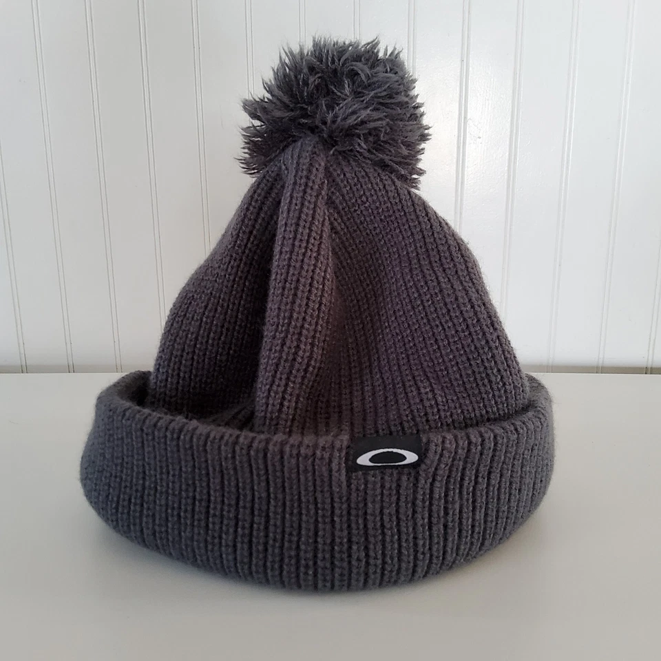 Gorra de invierno Oakley Pom Pom tejida gris talla única para la mayoría de las mujeres logotipo "O" usada en excelente estado Foto 1 de 4