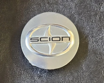 TAPA CENTRAL SCION TC 2-1/2" OEM 4 PUNTAS A PRESIÓN EN HIPER PLATA Foto 1 de 4