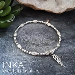 Sterling Silver stretch Oval bead 925 Stack Bracelet with Feather charm by INKA - Picture 1 of 10