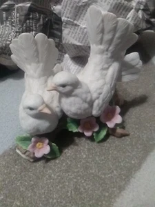 Dos palomas blancas sentadas en troncos con flores - Imagen 1 de 10
