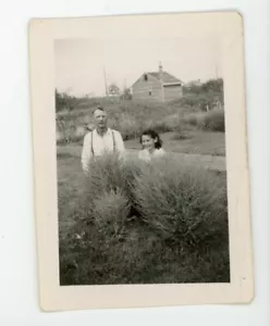 Foto giocosa uomo e ragazza anziani nascosti dietro cespuglio. foto istantanea vintage - Foto 1 di 3