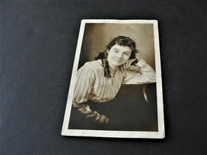 Joven Dama Sonriendo y sentada en una Silla-RPPC-Caja de Sellos-AZO (1918-1930). - Imagen 1 de 2