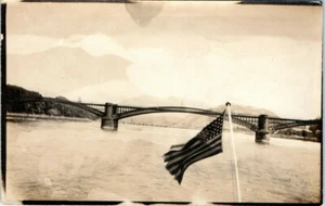 Old RPPC Postcard Patriotic United States Flag in Breeze Bridge Background US - Picture 1 of 2