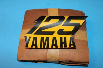 NUEVO FABRICANTE ORIGINAL YAMAHA 1974-1977 YZ125 TANQUE DE COMBUSTIBLE EMBLEMA PARTE # 537-24162-00 Foto 1 de 3