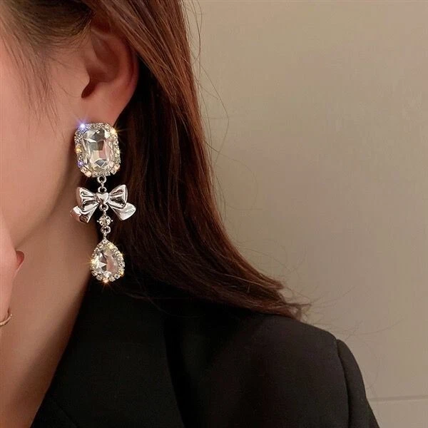 Orecchini a perno pendenti con cabochon bianchi e fiocco color argento 6.9x2.9cm - Immagine 1 di 1