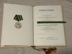 Medalla por servicios de fidelidad en el subteniente del NVA - certificado + carpeta - RDA 1967 - Imagen 1 de 5