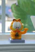 Garfield the Cat is styled as “lucky cat” statue with solar powered waving paw