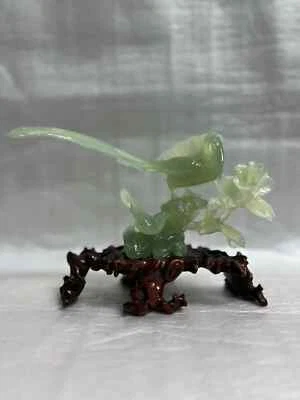 Talla china de jade verde claro con pájaros y flores sobre base de madera Foto 1 de 4