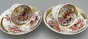 Par de tazas y platillos antiguos georgianos ingleses de porcelana de los años 1820 patrón dorado 69 - Imagen 1 de 18