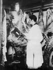 Female butcher, wearing a white coat, wields an axe cut large join Old Photo