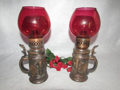 SET BRASS STEIN SHAPED CANDLE HOLDERS W CRANBERRY SHADE EMBOSSED GERMAN FIGURES  - Image 1 of 4