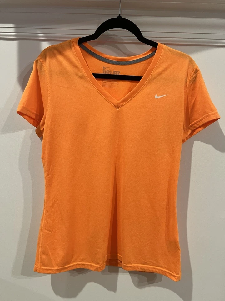 Camiseta deportiva Nike Dri-Fit naranja con cuello en V para mujer mediana Foto 1 de 3