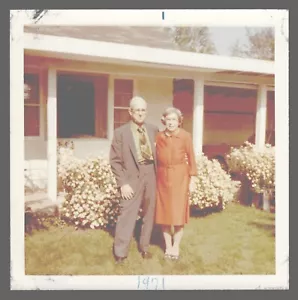 Found Photo 1971 Older Couple In Front of House Red Dress 3.5 x 3.5 - Picture 1 of 2