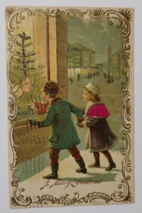 Postal Feliz Navidad Niña Niño Ventana Compras c1905 Sin Brillo - Imagen 1 de 2