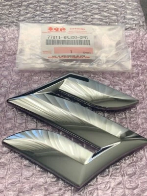 New OEM Genuine Suzuki GRAND VITARA 06-13 Front Grille Emblem 77811-65J00-0PG - Image 1 of 4