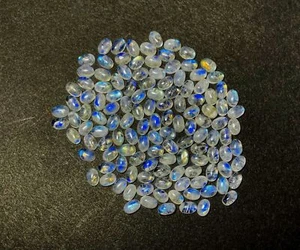 Lote de 157 piezas de piedras preciosas sueltas cabujón ovalado piedra lunar arco iris natural 4x6 mm 100 CT - Imagen 1 de 5