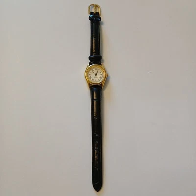 Reloj minimalista para mujer caja tono dorado número romano esfera redonda banda negra Foto 1 de 4