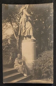 Foto real RPPC mujer sentada en escalones en parque cerca de estatua de niña con cabello largo 1914 - Imagen 1 de 3