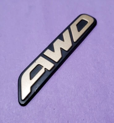 Bin17 used 00-04 Subaru Outback AWD Gold Rear Trunk Emblem Badge  - Image 1 of 3