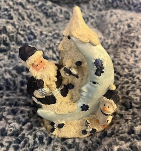 Blau-weißer Weihnachtsmann und Pinguin machen eine Eisskulptur Mond am Baum - Bild 1 von 4