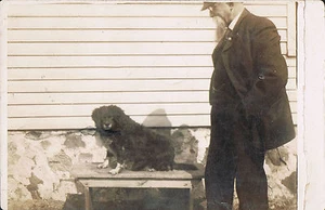 Postal con foto real RPPC ~ Hombre observa lindo perrito sentado en la mesa ~ perro - Imagen 1 de 2