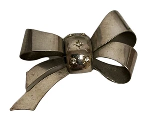 Spilla fiocco tono argento epoca 1900 vintage con 5 pietre sfaccettate finte diamantate  - Foto 1 di 5