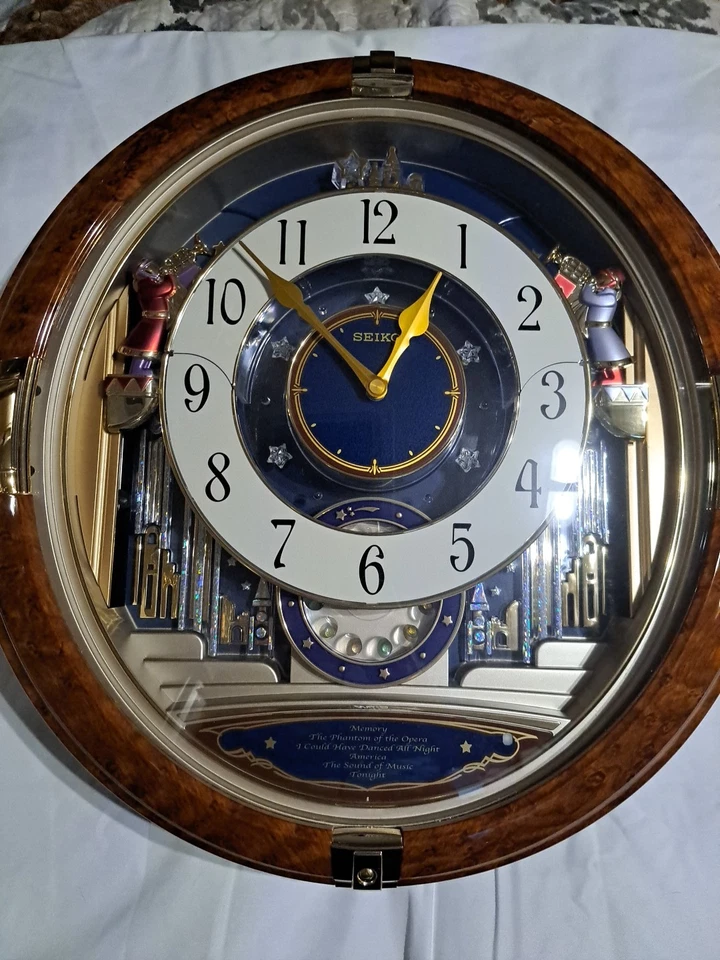 Reloj de pared Seiko Melodías en movimiento ángeles luces de movimiento música Broadway  Foto 1 de 4