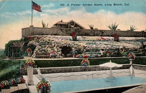 CARTOLINA SCENA GIARDINO FIORITO SPIAGGIA LUNGA CALIFORNIA - Foto 1 di 2