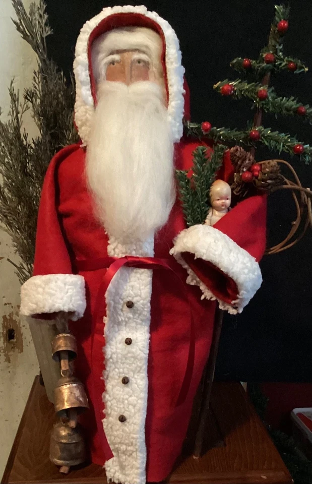 Papá Noel primitivo hecho a mano sosteniendo campanas de Navidad Foto 1 de 4