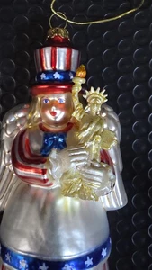 ÁNGEL PATRIÓTICO SOSTENIENDO ESTATUA DE LA LIBERTAD ORNAMENTO VIDRIO SOPLADO ROJO/BLANCO/AZUL - Imagen 1 de 3