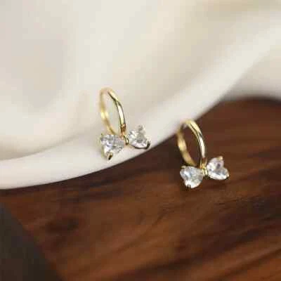 Pendientes minimalistas Pavé Huggie enchapados en oro de 18 quilates delicados con lazo de diamantes Foto 1 de 4