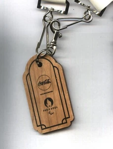 Paris 2024 Paralympics Coca Cola Olympic Village Service Wooden Keyring - Imagen 1 de 4