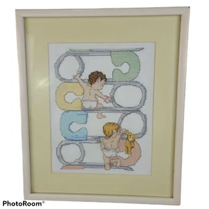 Alfileres de seguridad y bebé vintage enmarcados cosidos en cruz decoración de pared amarilla - Imagen 1 de 6