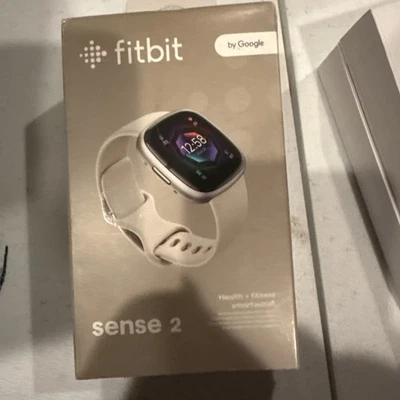 Reloj inteligente Fitbit Sense 2 aluminio platino con banda blanca lunar caja abierta Foto 1 de 4